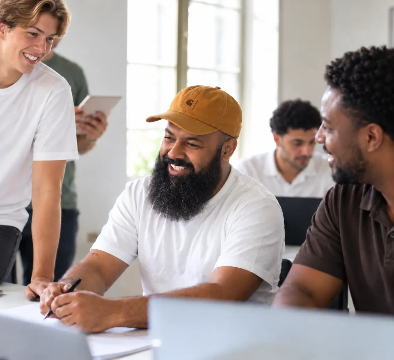 Team members laughing together at a desk in the office